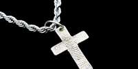 Cruz de prata presa a uma corrente prateada sobre fundo preto  Foto: Getty Images / BBC News Brasil