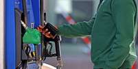 Um homem insere seu cart&atilde;o de cr&eacute;dito em uma bomba de combust&iacute;vel em Boston  Foto: Getty Images / BBC News Brasil