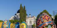 Esculturas de ovos ornamentados segundo a tradi&ccedil;&atilde;o ucraniana no munic&iacute;pio de Prudent&oacute;polis, com a Igreja S&atilde;o Josafat ao fundo  Foto: Daniel Teixeira/Estad&atilde;o / Estad&atilde;o