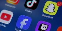 Instagram, TikTok, Snapchat, YouTube, Facebook, Twitch e Reddit: foto de ilustra&ccedil;&atilde;o de aplicativos de redes sociais em telefone celular. Lei australiana adotada em dezembro de 2025 por&iacute;be o uso por menores de 16 anos.  Foto: &copy; REUTERS - Hollie Adams / RFI