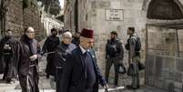 Policiais israelenses acompanham um grupo de frades franciscanos que caminham pela Via Crucis nesta Sexta-feira Santa, 3 de abril de 2026, na Cidade Velha de Jerusal&eacute;m.  Foto: AFP - MARCO LONGARI / RFI