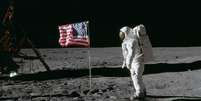 O astronauta Edwin E. Aldrin Jr., piloto do módulo lunar da primeira missão de pouso na Lua, posa para uma fotografia ao lado da bandeira dos Estados Unidos hasteada durante uma atividade extraveicular (EVA) da Apollo 11 na superfície lunar.  Foto: NASA