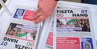 O jornal do partido de oposição TISZA, «TISZTA Hang», em um estande de campanha eleitoral em Budapeste, em 14 de fevereiro de 2026.  Foto: AFP - ATTILA KISBENEDEK / RFI