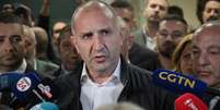 O l&iacute;der da coaliz&atilde;o "Bulg&aacute;ria Progressista" e ex-presidente Rumen Radev fala &agrave; imprensa na sede de seu partido, ap&oacute;s o encerramento das legislativas em S&oacute;fia, em 19 de abril de 2026.  Foto: AFP - DIMITAR KYOSEMARLIEV / RFI