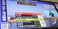 Televis&atilde;o japonesa exibe reportagem com alerta de tsunami, ap&oacute;s um terremoto de magnitude 7,4 na costa nordeste do pa&iacute;s nesta segunda-feira, 20 de abril de 2026.  Foto: REUTERS - Issei Kato / RFI