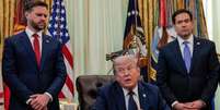 Presidente Trump sentado na cadeira no Salão Oval ao lado do vice-presidente JD Vance e do secretário de Estado, Marco Rubio  Foto: Reuters / BBC News Brasil