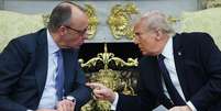 Trump e Merz conversam no Salão Oval. Eles estão sentados e inclinados um em direção ao outro. Trump aponta o dedo para Merz.  Foto: Getty Images / BBC News Brasil