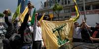 Apoiadores do Hezbollah agitam a bandeira da mil&iacute;cia pr&oacute;-iraniana em 17 de abril de 2026 em Dahiyeh, um sub&uacute;rbio de Beirute.  Foto: RFI
