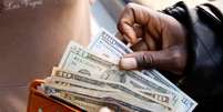 Pessoa exibe notas de dólar americano após sacar dinheiro em um banco em Harare, Zimbábue, 9 de julho de 2019. REUTERS/Philimon Bulawayo  Foto: Reuters