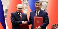 Putin e Xi Jinping assinaram mais de 20 acordos comerciais e tecnológicos, além de uma declaração sobre uma "ordem mundial multipolar"  Foto: Reuters / BBC News Brasil