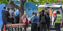 Equipes de emerg&ecirc;ncia do Crescente Vermelho e policiais transferem os corpos de turistas italianos de uma lancha da pol&iacute;cia para uma ambul&acirc;ncia em Mal&eacute;, nas Maldivas, em 19 de maio de 2026.  Foto: AFP - MOHAMED AFRAH / RFI