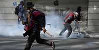 Manifestantes correm durante uma marcha exigindo a ren&uacute;ncia do presidente boliviano Rodrigo Paz, em 18 de maio de 2026, em La Paz, Bol&iacute;via.  Foto: Reuters / BBC News Brasil
