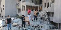 Moradores inspecionam os danos no local de um ataque israelense noturno na cidade de Tiro, no sul do L&iacute;bano, em 23 de maio de 2026.  Foto: REUTERS - Aziz Taher / RFI