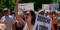 Manifestante segura placa com os dizeres em espanhol: "Direito à moradia" durante uma manifestação realizada em Madri, Espanha, em 24 de maio.  Foto: RFI
