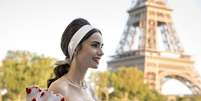 Emily (Lily Collins) diante da Torre Eiffel em Paris  Foto: Divulga&ccedil;&atilde;o