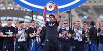 D&eacute;sir&eacute; Dou&eacute; celebra com o trof&eacute;u da Champions durante o desfile dos jogadores do Paris Saint-Germain - Foto: Franco Arland/Getty Images / Jogada10