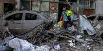 Morador de Kiev carrega alguns pertences em meio &agrave; destrui&ccedil;&atilde;o causada por um ataque russo  Foto: DW / Deutsche Welle
