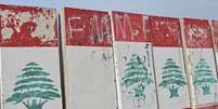 Uma bandeira libanesa colocada sobre blocos de concreto ao longo da costa de Beirute, capital do L&iacute;bano, chama a aten&ccedil;&atilde;o enquanto civis deslocados lutam para sobreviver em abrigos improvisados ​​por toda a cidade, em 14 de abril de 2026. (Foto de Elif &Atilde;zt&uuml;rk/Anadolu via Getty Images)  Foto: Getty Images