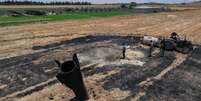 Agricultores resfriam área atingida por destroços de míssil perto de Najha, na Síria, após ataques no conflito entre Irã e Israel.  Foto: RFI