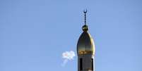 Uma nuvem de fumaça é vista no céu perto do minarete de uma mesquita na cidade de Hebron, na Cisjordânia, Palestina, após uma tentativa de interceptação de mísseis iranianos em 8 de junho de 2026  Foto: Mamoun Wazwaz/Anadolu via Getty Images