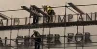 Pessoas gritam &ldquo;derrubem isso&rdquo; enquanto os trabalhadores se preparam para remover o nome de Trump do Kennedy Center  Foto: Reprodu&ccedil;&atilde;o/X/@EdKrassen