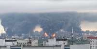 Densas colunas de fumaça, acompanhadas por chamas, se elevam de uma refinaria de petróleo em Moscou.  Foto: Reuters / BBC News Brasil