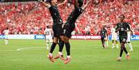 Jonathan David celebra um dos tr&ecirc;s gols que marcou na goleada sobre o Catar com Stephen Eustaquio - Foto: Fran Santiago/Getty Images / Jogada10