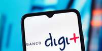 Nesta fotoilustra&ccedil;&atilde;o, o logotipo do Banco Digimais aparece exibido na tela de um smartphone.  Foto: LightRocket via Getty Images / BBC News Brasil