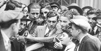 Mensageiros de corretoras se aglomeram em torno de um jornal ap&oacute;s a primeira quebra da bolsa de valores de Wall Street, em 24 de outubro de 1929  Foto: Getty Images / BBC News Brasil