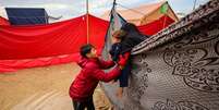 Duas crian&ccedil;as palestinas brincam em um acampamento improvisado que abriga palestinos deslocados no campo de refugiados de Maghazi, no centro da Faixa de Gaza, em 25 de novembro de 2025.  Foto: RFI
