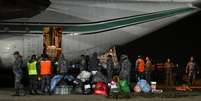 Membros da For&ccedil;a A&eacute;rea da Bol&iacute;via e equipes de resgate carregam ajuda humanit&aacute;ria em uma aeronave C-130 H&eacute;rcules, que ser&aacute; enviada para opera&ccedil;&otilde;es de busca e resgate ap&oacute;s os terremotos na Venezuela. Base A&eacute;rea &ldquo;Diablos Negros&rdquo;, em El Alto, Bol&iacute;via, em 29 de junho de 2026.  Foto: REUTERS - Claudia Morales / RFI
