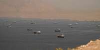 Dezenas de embarca&ccedil;&otilde;es cruzam o Estreito de Ormuz, cercado por montanhas rochosas, visto da pen&iacute;nsula de Musandam, em Om&atilde;.
  Foto: Reuters / BBC News Brasil