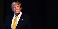 Trump usando um terno com uma gravata amarela. O fundo &eacute; preto.  Foto: Getty Images / BBC News Brasil