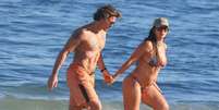 R&ocirc;mulo Arantes Neto e Mari Saad foram &agrave; praia neste s&aacute;bado, 18 de julho de 2026.  Foto: AGNews, Dan Delmiro / Purepeople