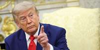 President Donald Trump pointing his finger. He has a serious look on his face and is wearing a blue suit with a white shirt and red tie.  Foto: Getty Images / BBC News Brasil