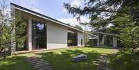 Casa térrea com anexo, em meio a um jardim arborizado em dia de sol  Foto: Symbiotic House/Masaya Yoshimura/A House in Japan, Ed. Gestalten / BBC News Brasil