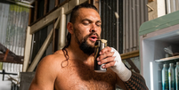 Jason Momoa, hoje aos 47 anos, o Blanka de 'Street Fighter' e eterno 'Aquaman': 'Minha m&atilde;e sempre tomava cervejas de qualidade. Ela acabou me criando bebendo as melhores'.  Foto: Youtube, Men's Health / Enhanced with Google AI / Purepeople