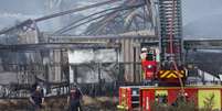 Bombeiros diante do dep&oacute;sito de res&iacute;duos industriais que pegou fogo em Gandrange, no leste da Fran&ccedil;a, provocando o confinamento por algumas horas de cerca de 30 mil pessoas em 2 de agosto de 2026.  Foto: AFP - ROMEO BOETZLE / RFI