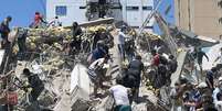 Pesoas buscam sobreviventes entre os escombros de um prédio derrubado pelo terremoto  Foto: Getty Images / BBC News Brasil
