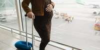 Imagem ilustrativa de uma mulher gr&aacute;vida com uma mala em um aeroporto.  Foto: Getty Images / BBC News Brasil