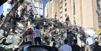 Moradores vasculham os escombros de um pr&eacute;dio que desabou ap&oacute;s um terremoto, em Cali, na Col&ocirc;mbia - 10 de agosto de 2026  Foto: Reuters/Juan Pablo Arbelaez