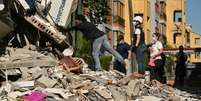 Homem verifica interior de casa que ruiu ap&oacute;s terremoto em Pereira, Col&ouml;mbia, em 11 de agosto de 2026.  Foto: AFP - LUIS ACOSTA / RFI