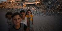 Crianças palestinas posam para foto em meio a escombros em Jabalia, ao norte da Cidade de Gaza  Foto: ANSA / Ansa - Brasil