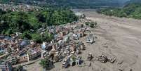 Casas encontram-se parcialmente submersas em &aacute;guas barrentas &agrave; beira de um rio ap&oacute;s inunda&ccedil;&otilde;es repentinas em Trishuli Bazar, no distrito de Nuwakot, no Nepal  Foto: Prabin Ranabhat/AFP via Getty Images / BBC News Brasil