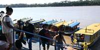Em 11 de agosto de 2026, pessoas chegam de barco pelo rio Mamor&eacute; em Guayaramer&iacute;n, na fronteira entre a Bol&iacute;via e o Brasil, no departamento de El Beni, na Bol&iacute;via.  Foto: &copy; AIZAR RALDES / AFP / RFI