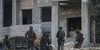 Soldados israelenses removem o corpo de um palestino morto de uma casa em construção, nos arredores da cidade de Jenin, no norte da Cisjordânia ocupada por Israel, em 28 de agosto de 2026.  Foto: AFP - JAAFAR ASHTIYEH / RFI