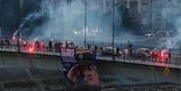 Apoiadores de Ratko Mladic exibem sua foto e acendem sinalizadores para homenagear o ex-general s&eacute;rvio na ponte Varadinski, em Novi Sad, na S&eacute;rvia, em 27 de agosto de 2026.  Foto: RFI