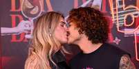 Douglas Sampaio e sua namorada se beijam no Rock in Rio  Foto: AGNEWS