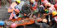 Equipes resgatam um homem preso na lama ap&oacute;s inunda&ccedil;&otilde;es no Nepal.  Foto: RFI