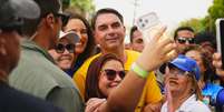 Flávio Bolsonaro tira foto com apoiadores em ação da campanha  Foto: Divulgação / Estadão